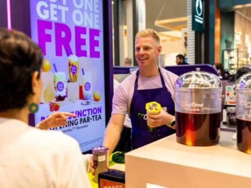 Retail and hospitality staff wearing branded workwear uniforms while serving customers.