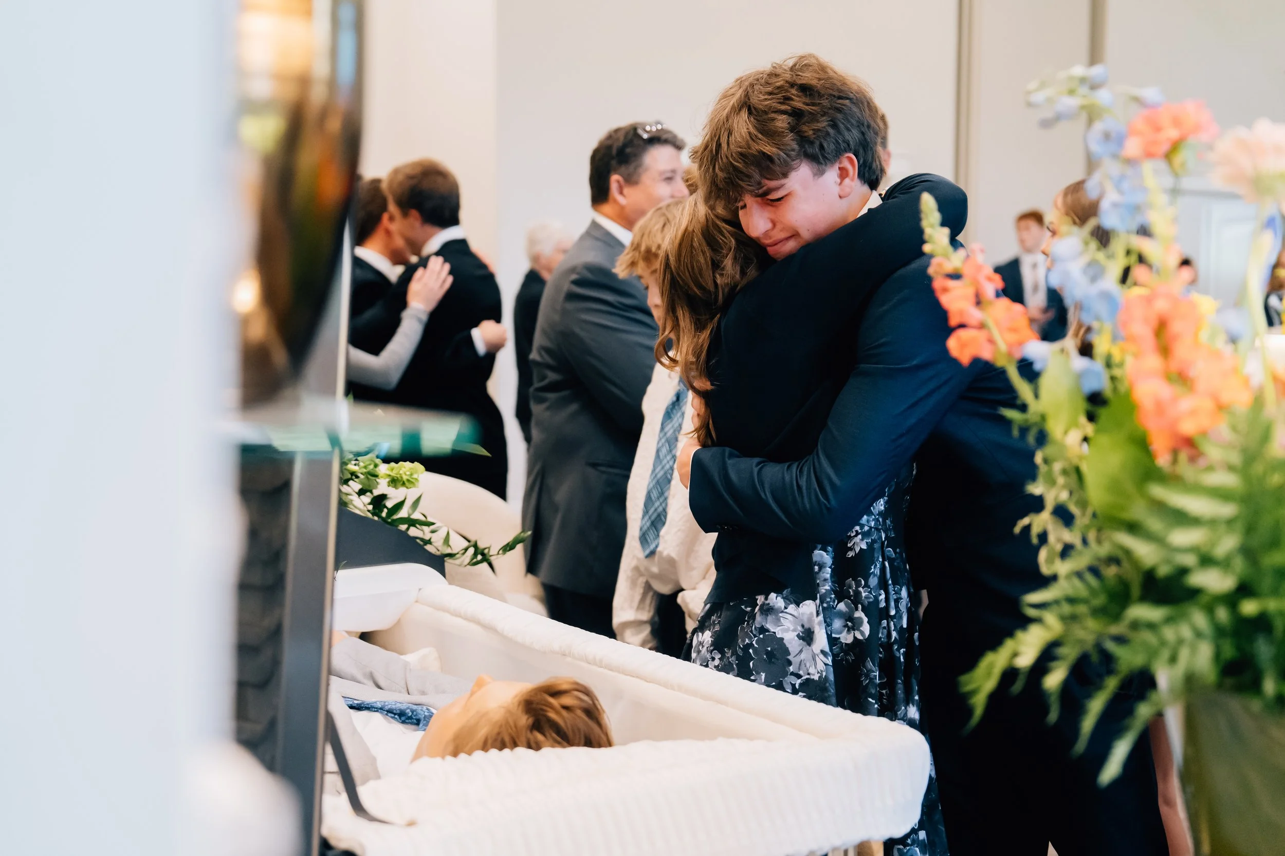 Friends and family mourning the loss of Noah Scribner at his viewing prior to his funeral.