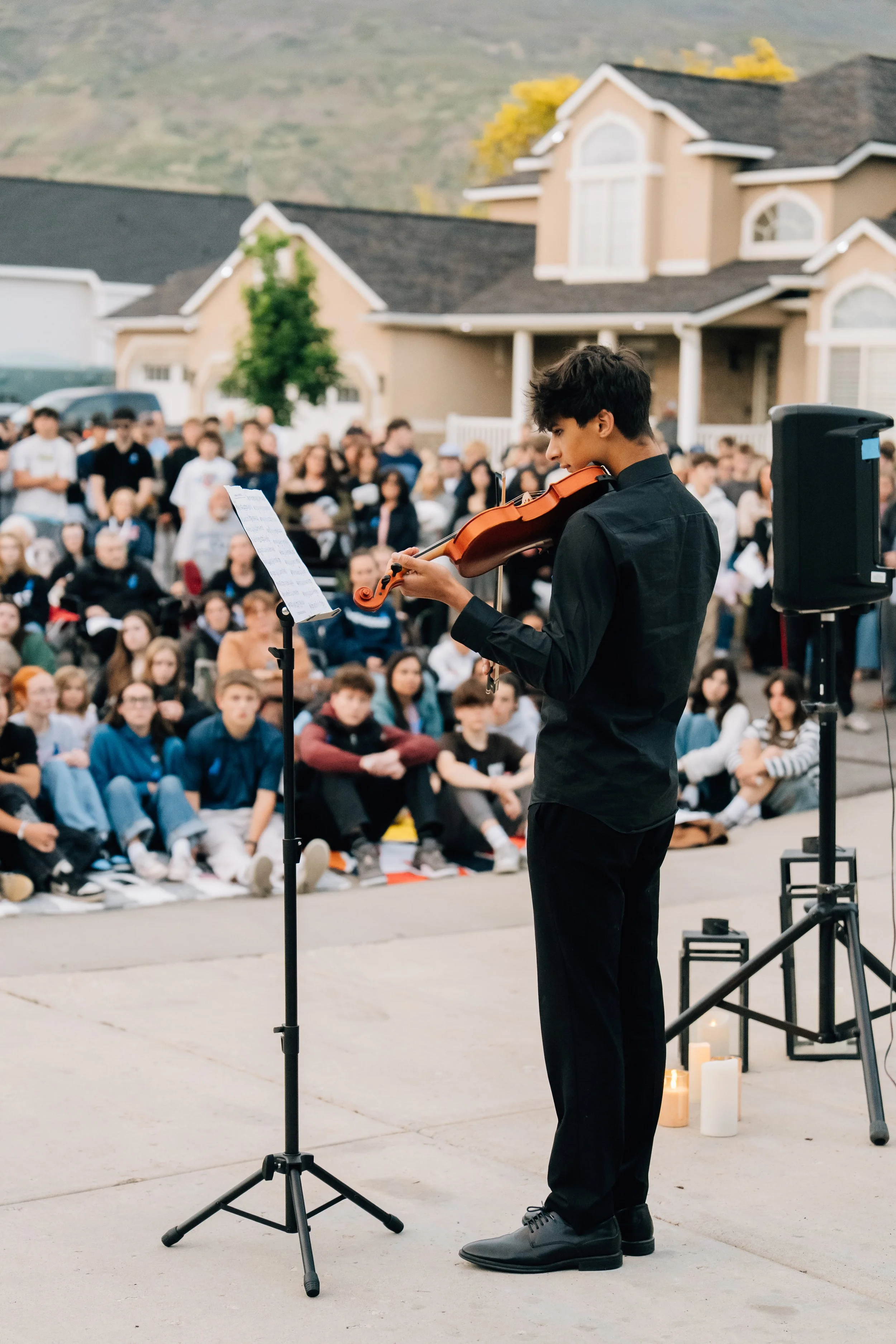 A friend playing the violin in memory of Noah Scribner at his candlelight vigil after his death.