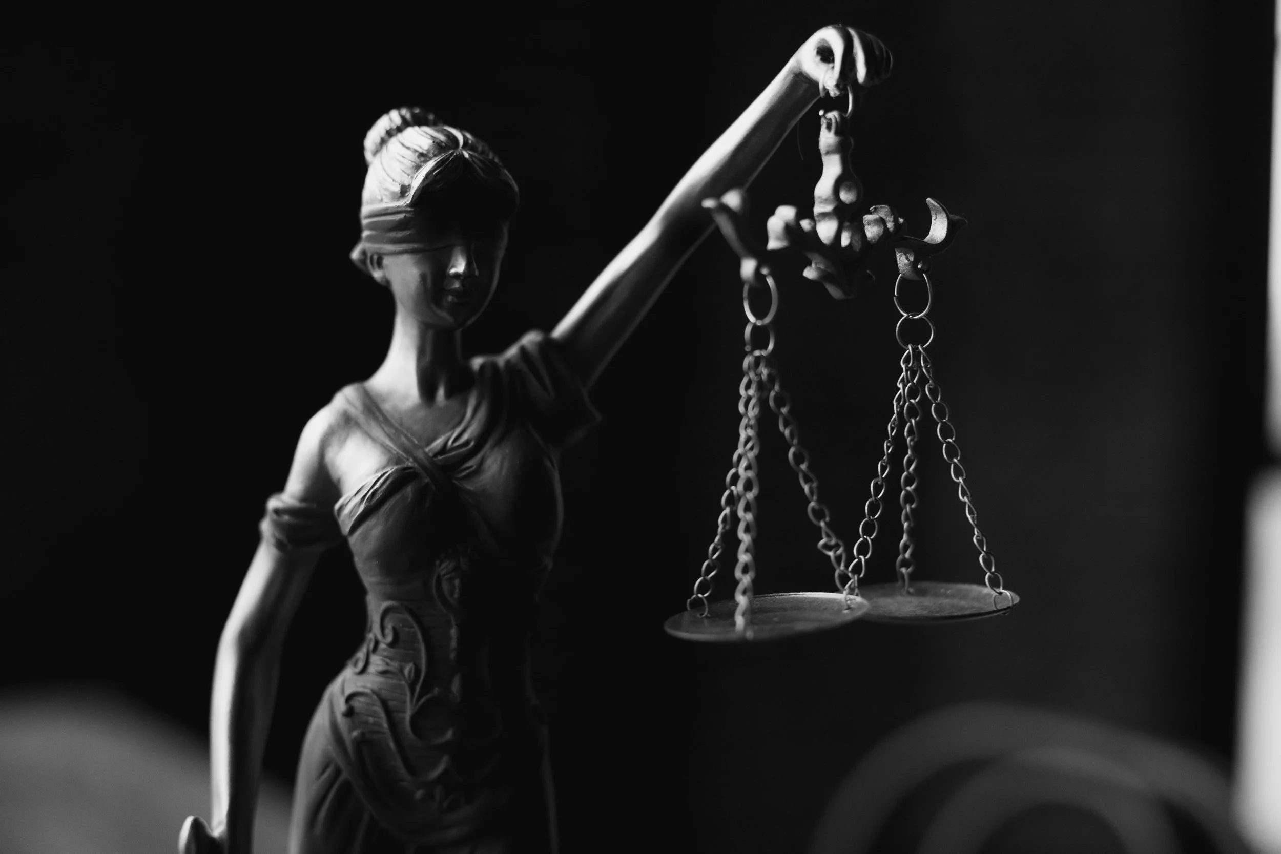 A grayscale lady justice figurine. Representing the insights of Bernie Burk Law Professor on ethical leadership.