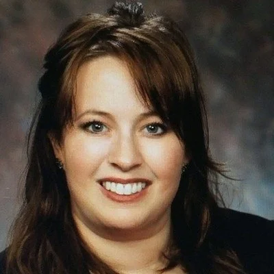 A woman with shoulder-length brown hair smiling at the camera.
