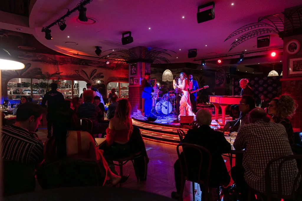 Live jazz band performing on stage in a dimly lit restaurant, with seated audience enjoying the music.