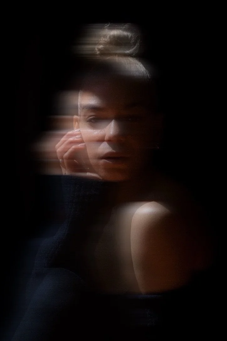 A portrait photograph of a woman with blurred motion effects, enhancing a mysterious and artistic atmosphere.