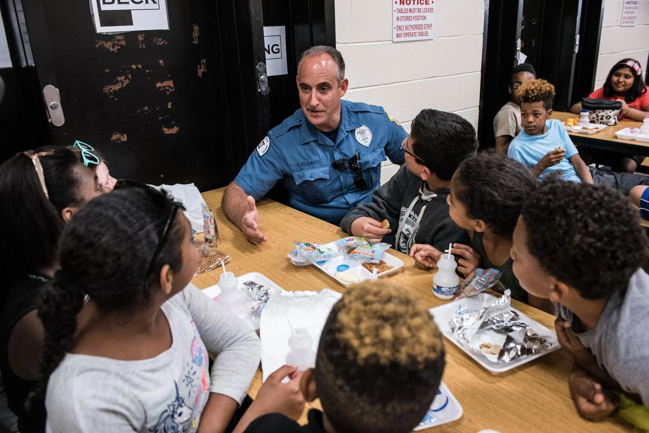 A school police officer shares lunch with school children in Camden.