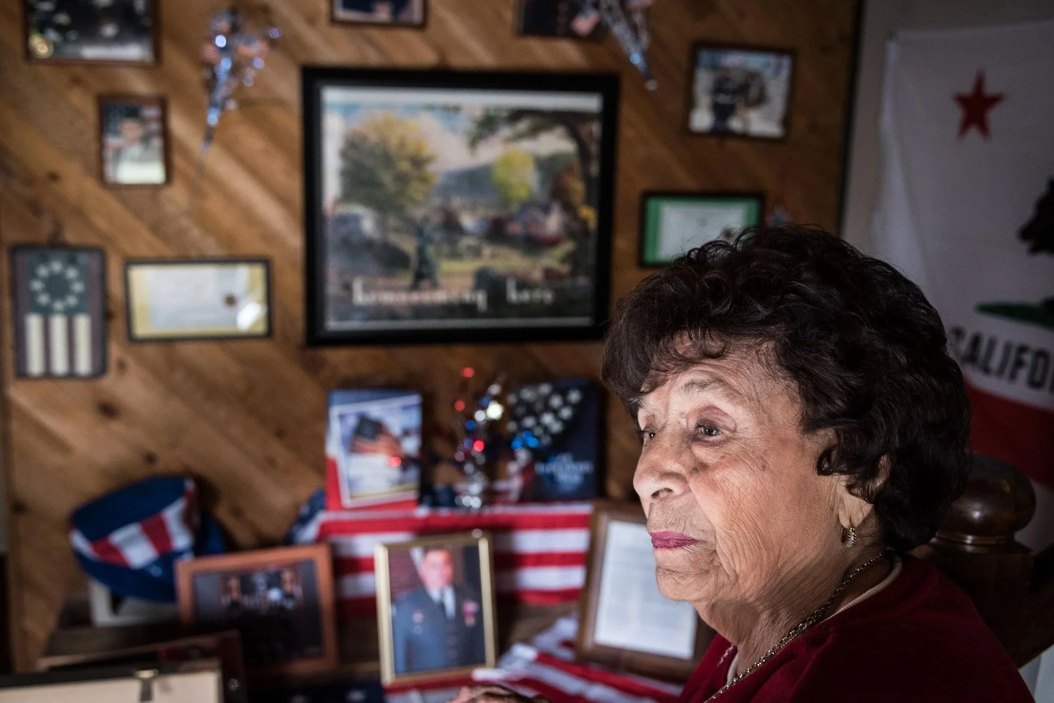 A woman sits in front of memorial day memorabilia in Orange County.