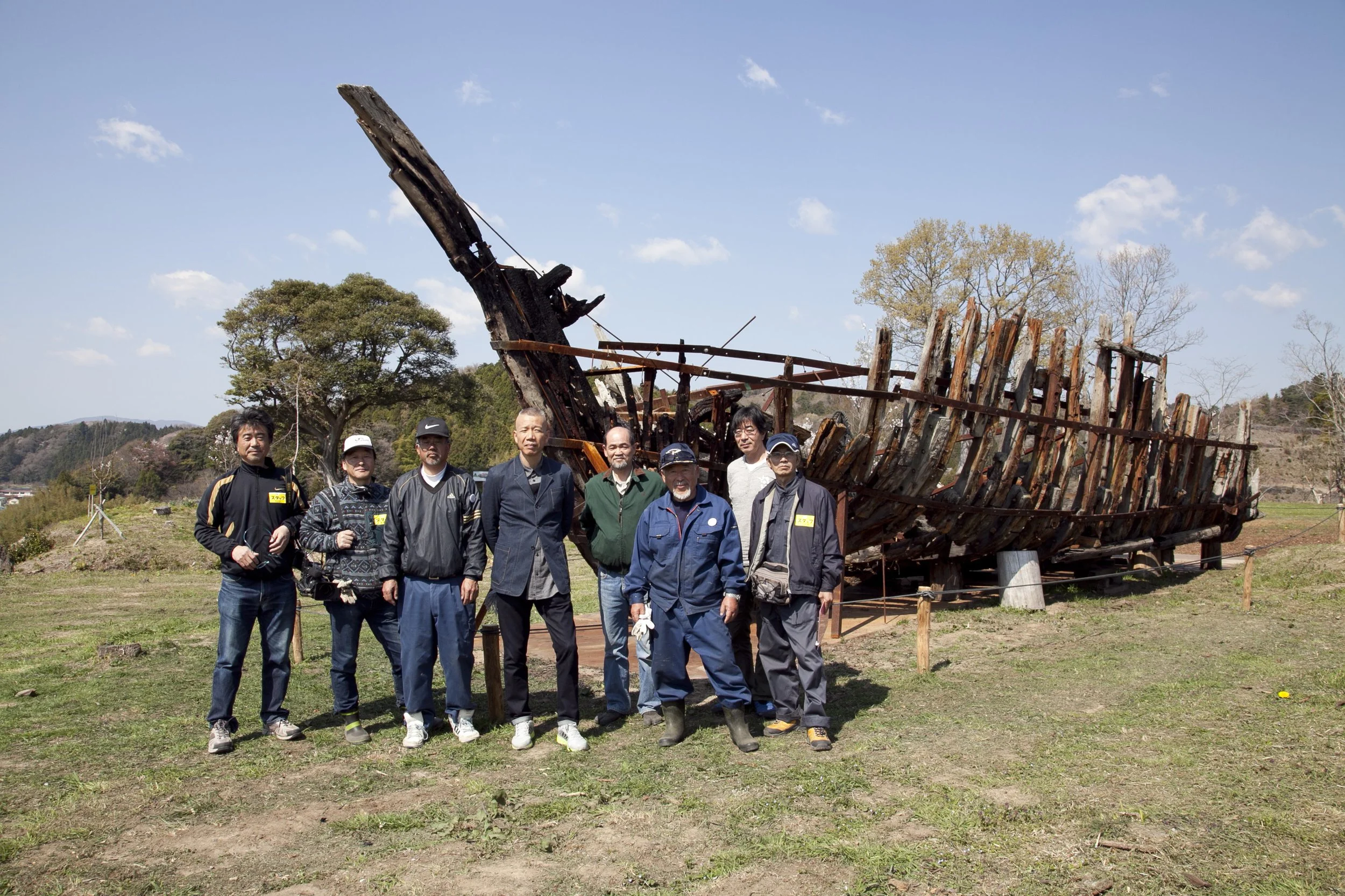  Cai and the Iwaki Committee in front of the boat used to be part of  Kaikou—The Keel , 2014. Photo by Wen-You Cai, courtesy Cai Studio 
