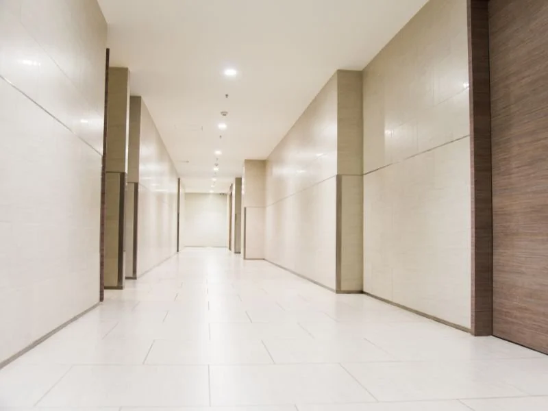 Empty hallway with beige walls and light-colored flooring in a modern building.
