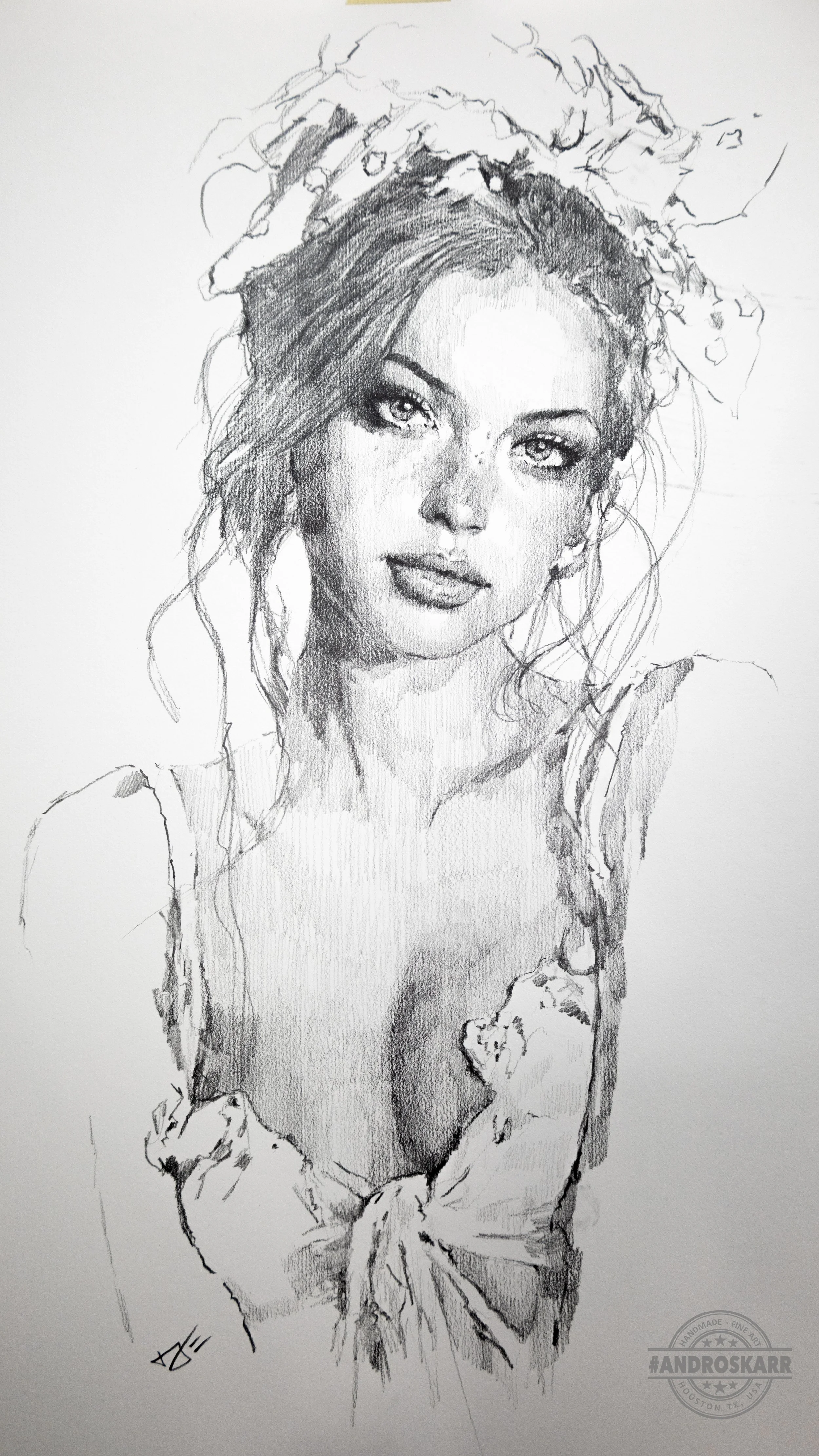 A detailed black and white sketch of a woman with long, wavy hair, wearing a bikini top with ruffles and a floral headband. The drawing emphasizes her expressive eyes, full lips, and delicate features.
