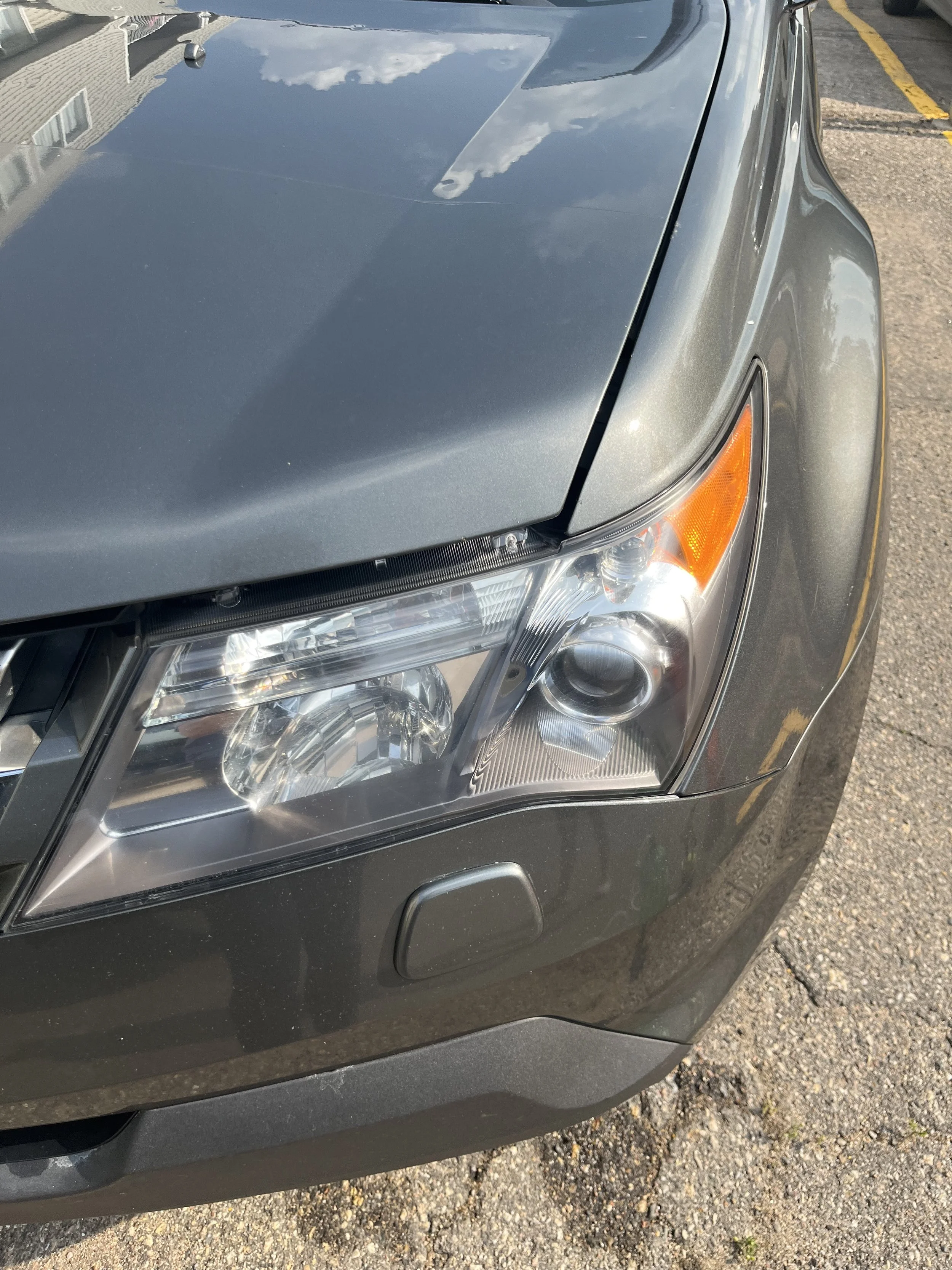 Picture of a drive's side headlight of an Acura SUV after the headlight restoration procedure.