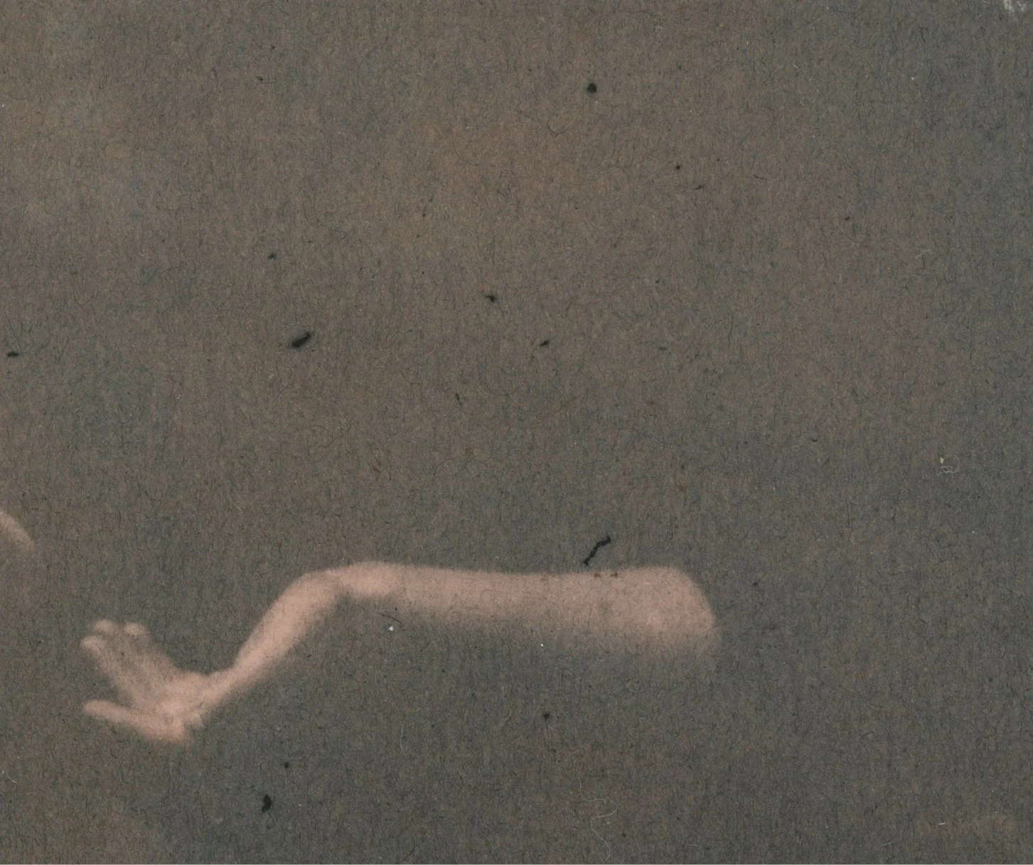 Una foto di un braccio umano disteso su una superficie scura.