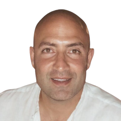 A smiling man with a shaved head wearing a white shirt, looking directly at the camera.