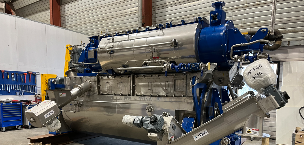 Stort industrielt maskineri i et verksted med verktøy og utstyr på veggen.