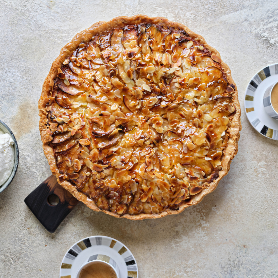 An almond tart with a golden crust topped with sliced almonds.