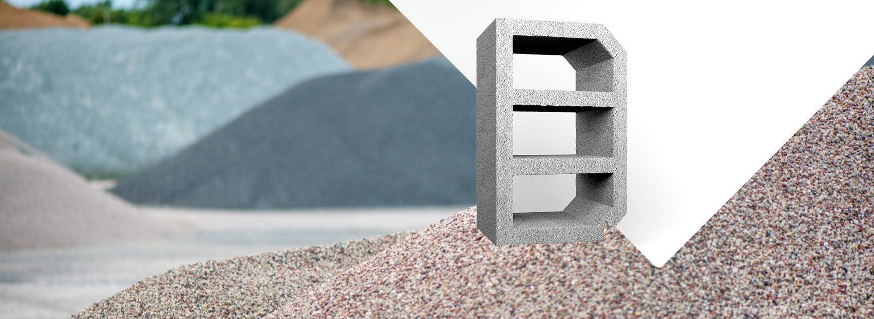 Farklı renklerde kum yığınları ve ortasında beton blok bulunan bir sahne.