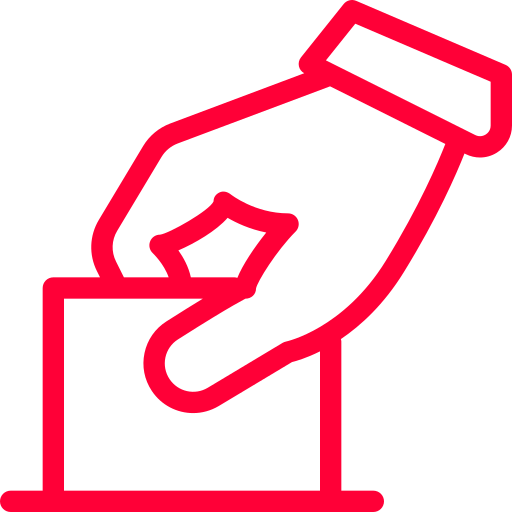 En hand lägger en valsedel i en låda