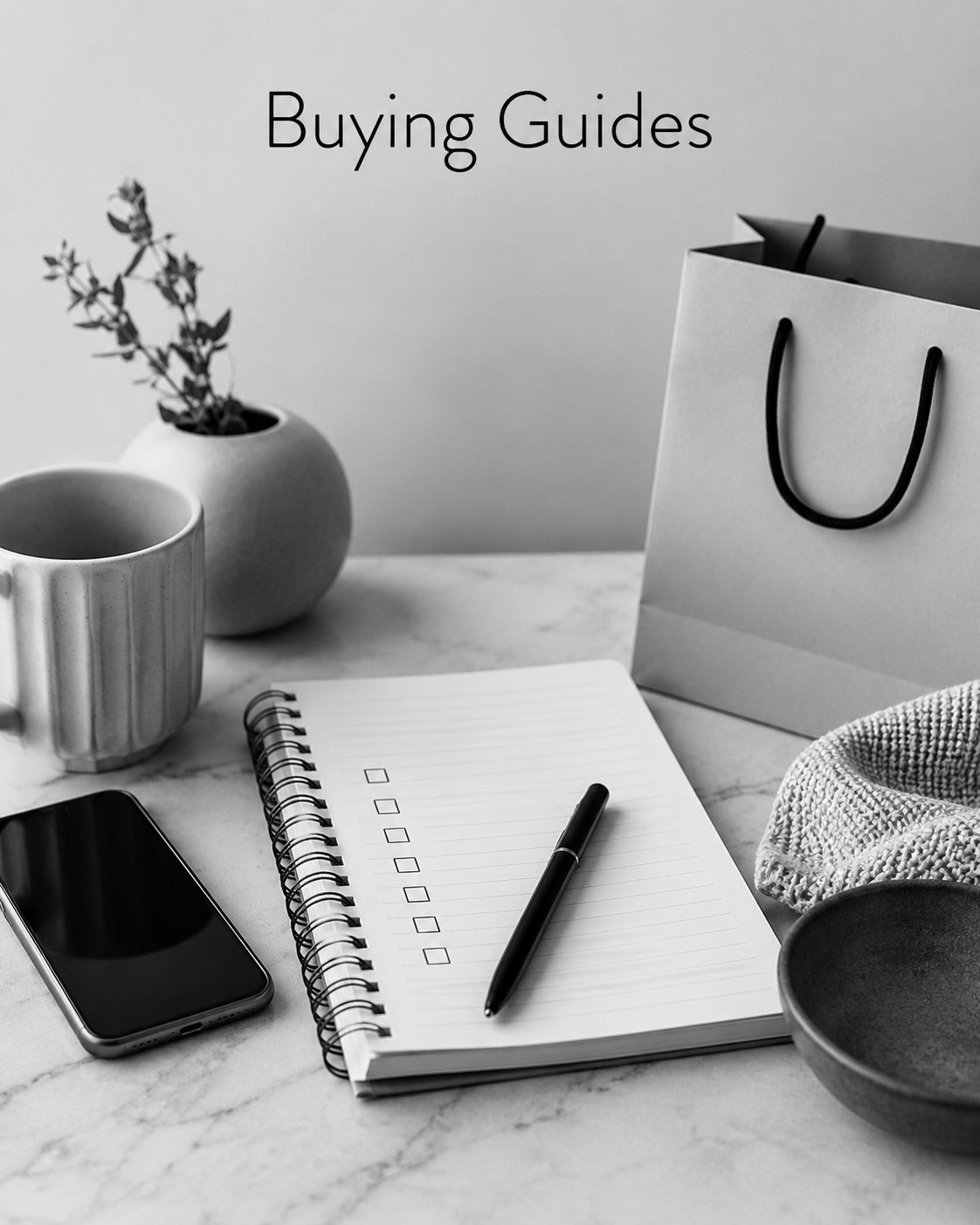 Black-and-white image of a checklist, pen, phone, shopping bag and product guide notebook.