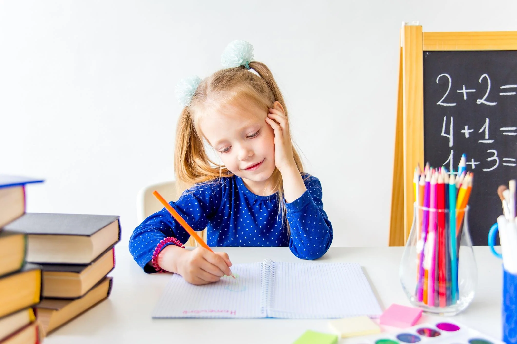 Young primary school student completing mathematics exercises at a desk.