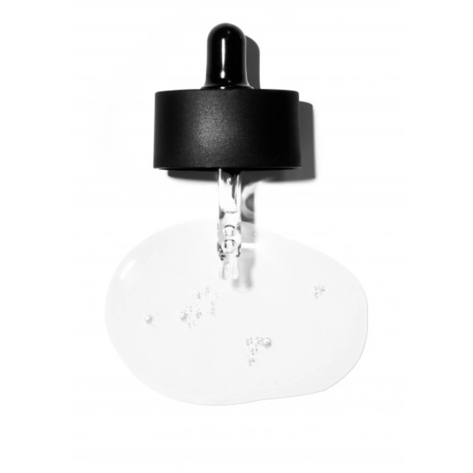 Image macro d'une goutte de sérum transparent et limpide avec bulles. Compte-gouttes noir suspendu au-dessus. Texture du sérum COSRX Niacinamide sur fond blanc.