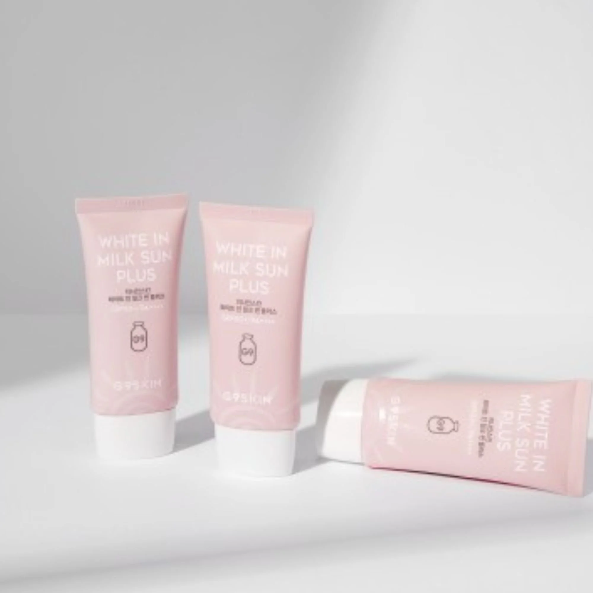 Trois tubes de G9SKIN White In Milk Sun Plus SPF50+ PA++++. Crème solaire K-Beauty rose pâle pour le corps et le visage.