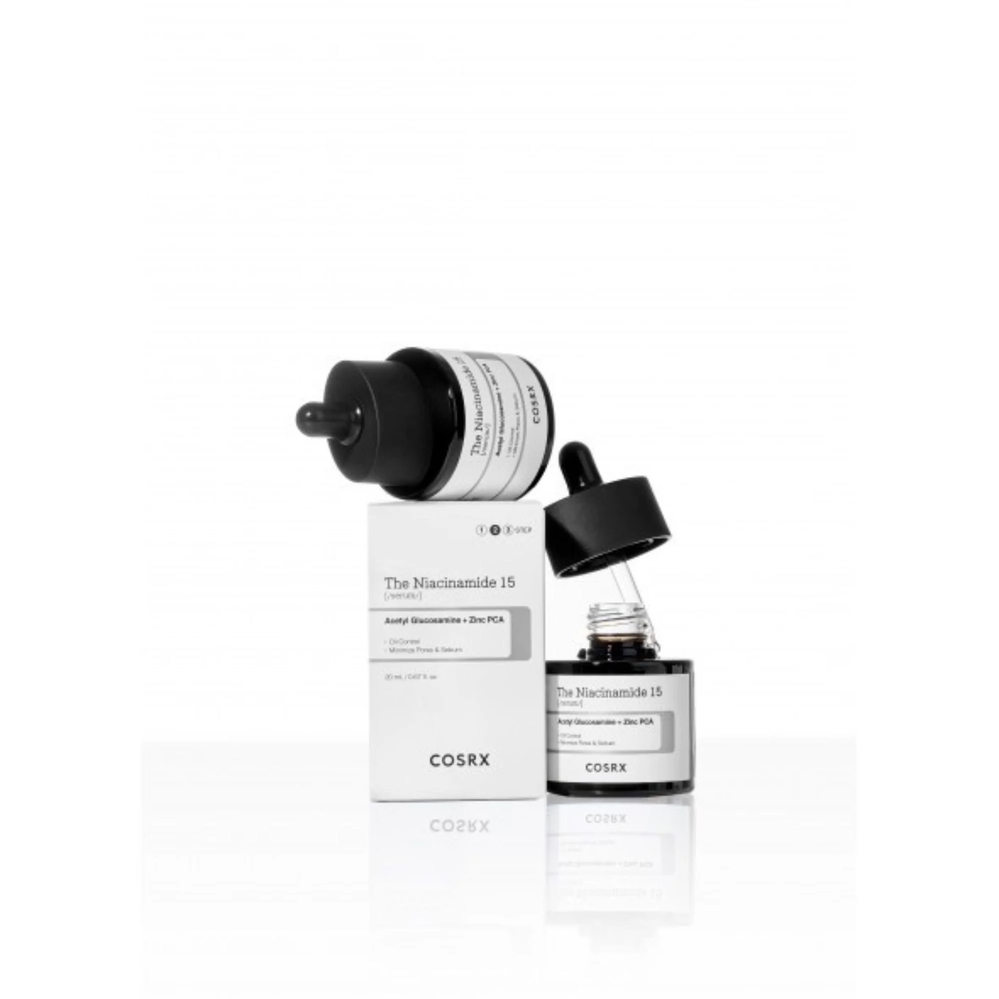 Photo de studio du sérum COSRX The Niacinamide 15. Flacon noir ouvert et boîte blanche avec reflet, sérum K-Beauty niacinamide.