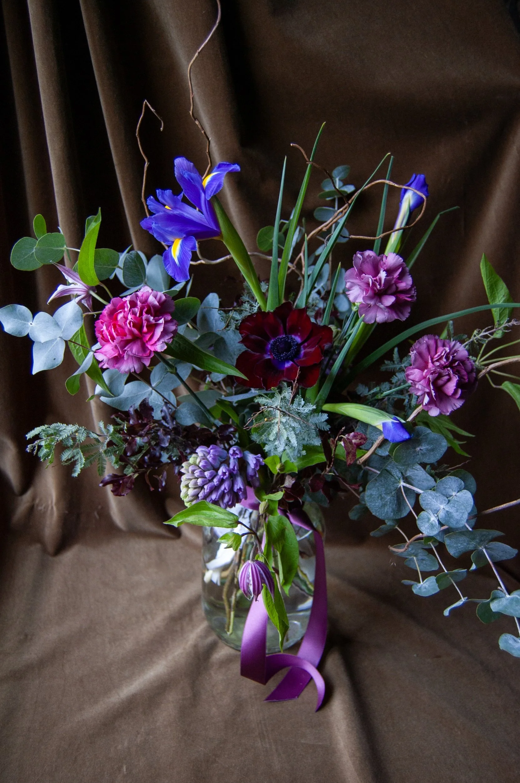 Jewel toned spring flowers in a glass jar