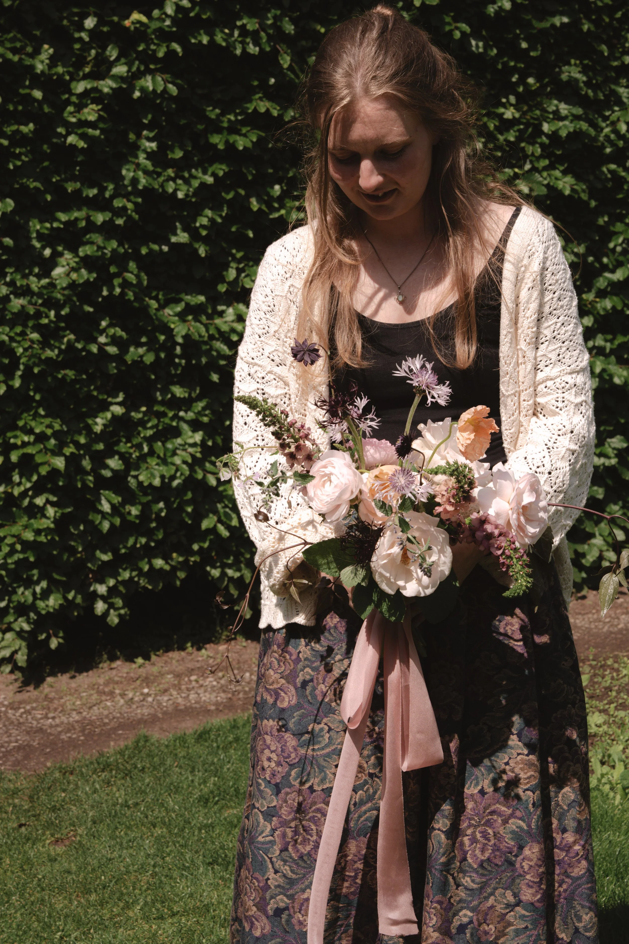 Close up of Katie, the head florist, holding a natural and wild wedding bouquet