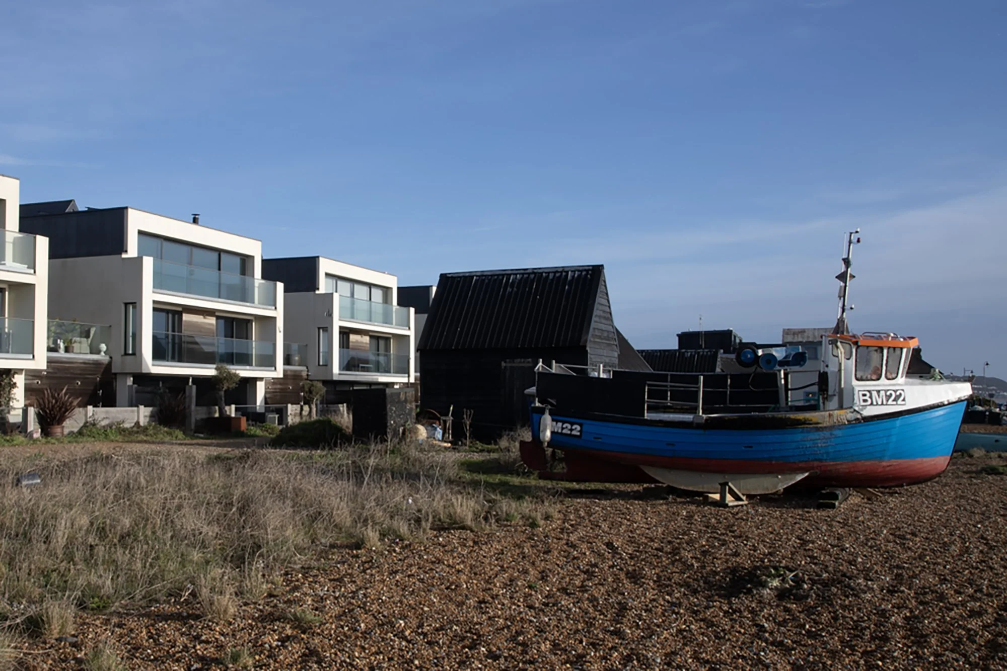 Fisherman's Beach Hythe, Kent showing traditional fishing boat in the foreground and modern accommodation in the background