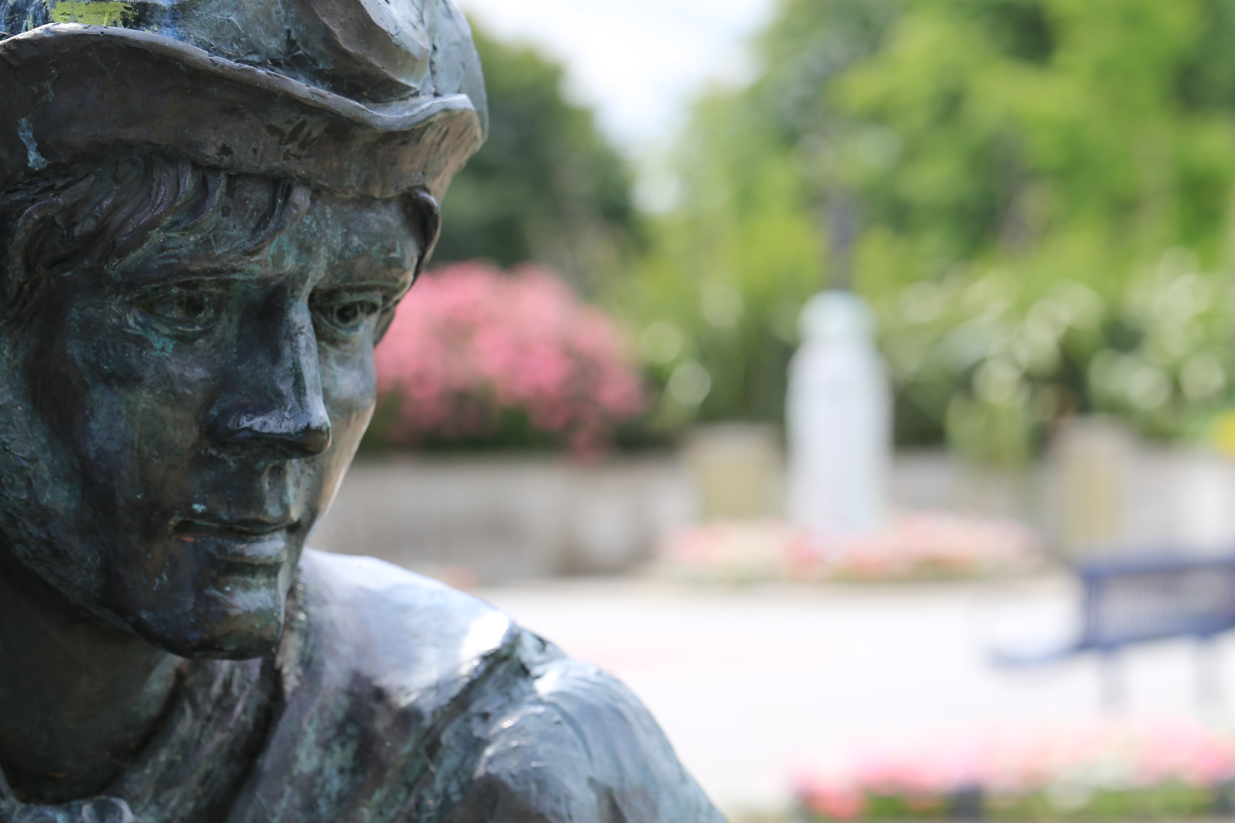 Canal worker statue with War memorial in the background at Hythe, Kent