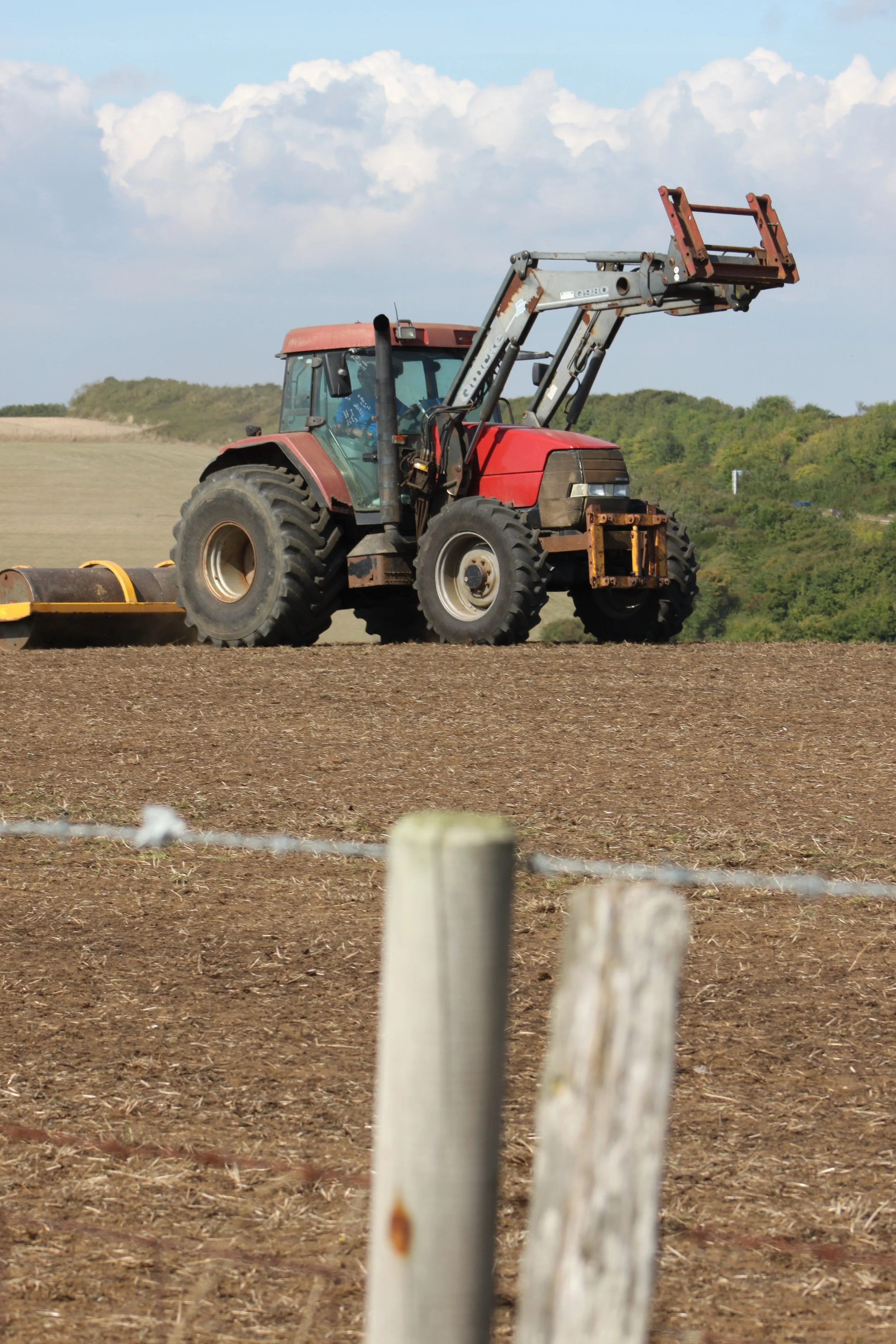 Working farmer with red tractor at Caple-le-Ferne, Kent