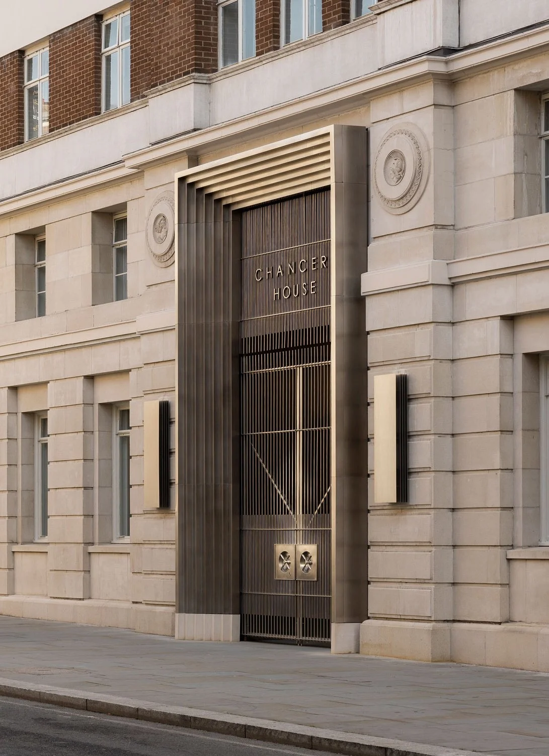 Exterior view of a modern building with a metal gate labeled 'Changer House' in a city street