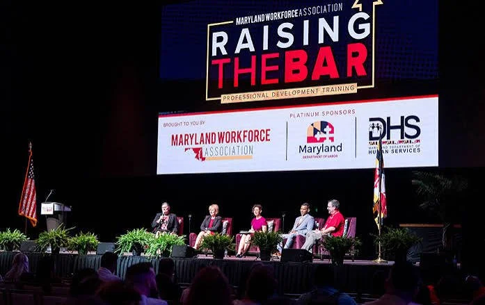 Picture of a previous conference event with speakers seated on a stage