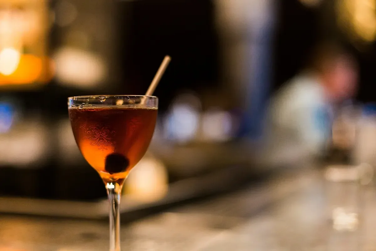 Bernsteinfarbener Cocktail im Stielglas auf einer Bar – Symbolbild für ein Teamevent mit Cocktailkurs.