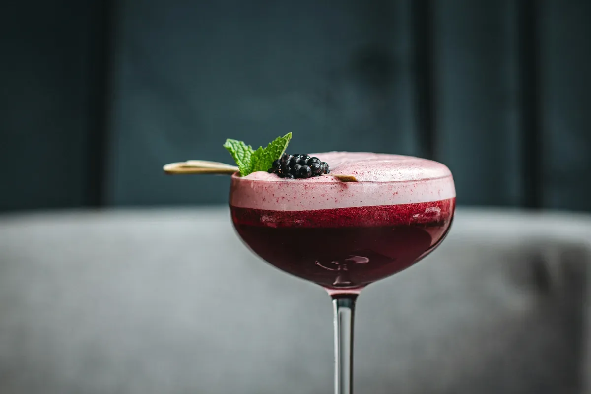 Roter Beeren-Cocktail mit Schaumkrone, Brombeere und Minze beim Cocktailkurs in Hamburg von Cocktail Circle.