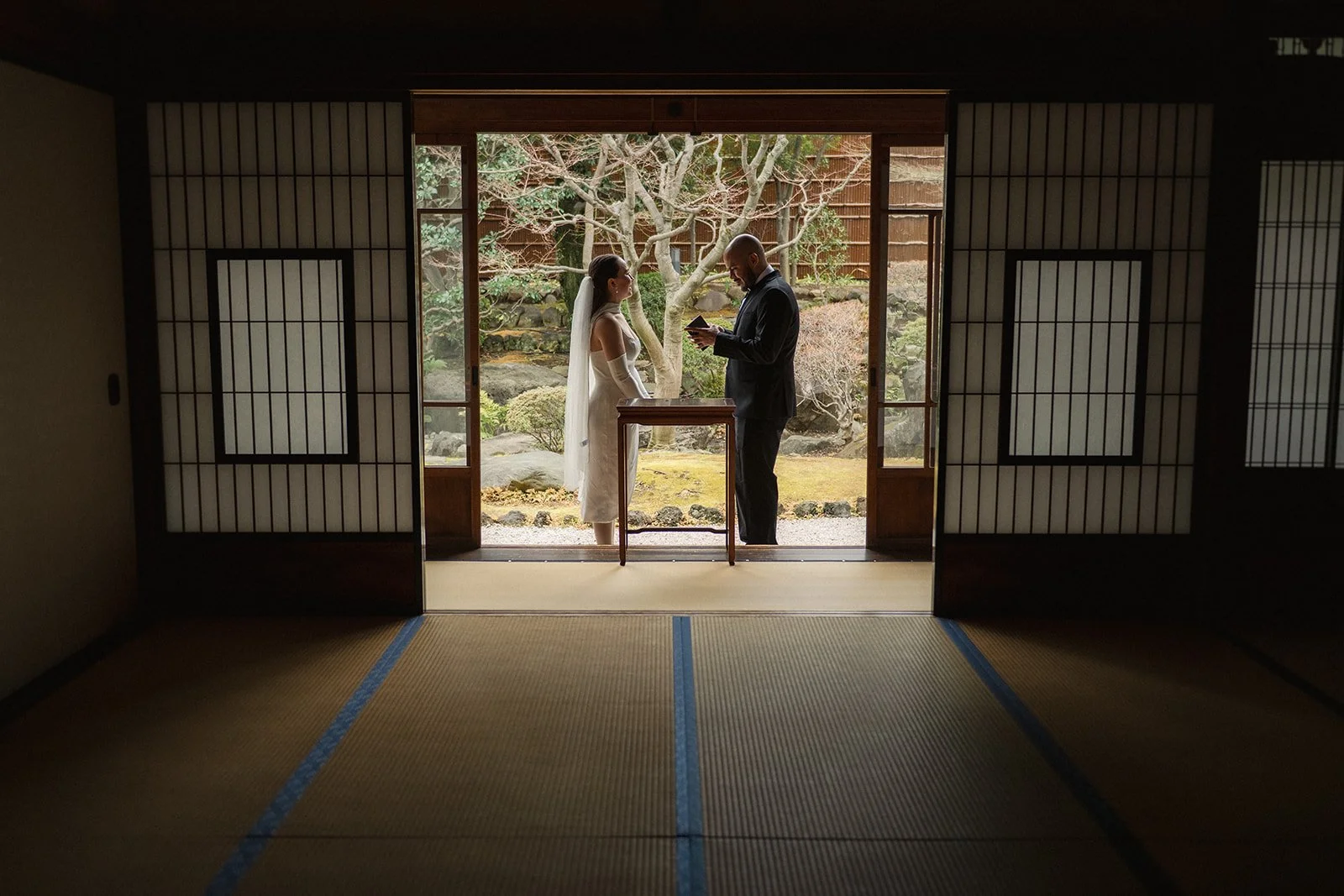 Young couple exchange vows in a beautiful Japanese house.  The mood is quiet and romantic.