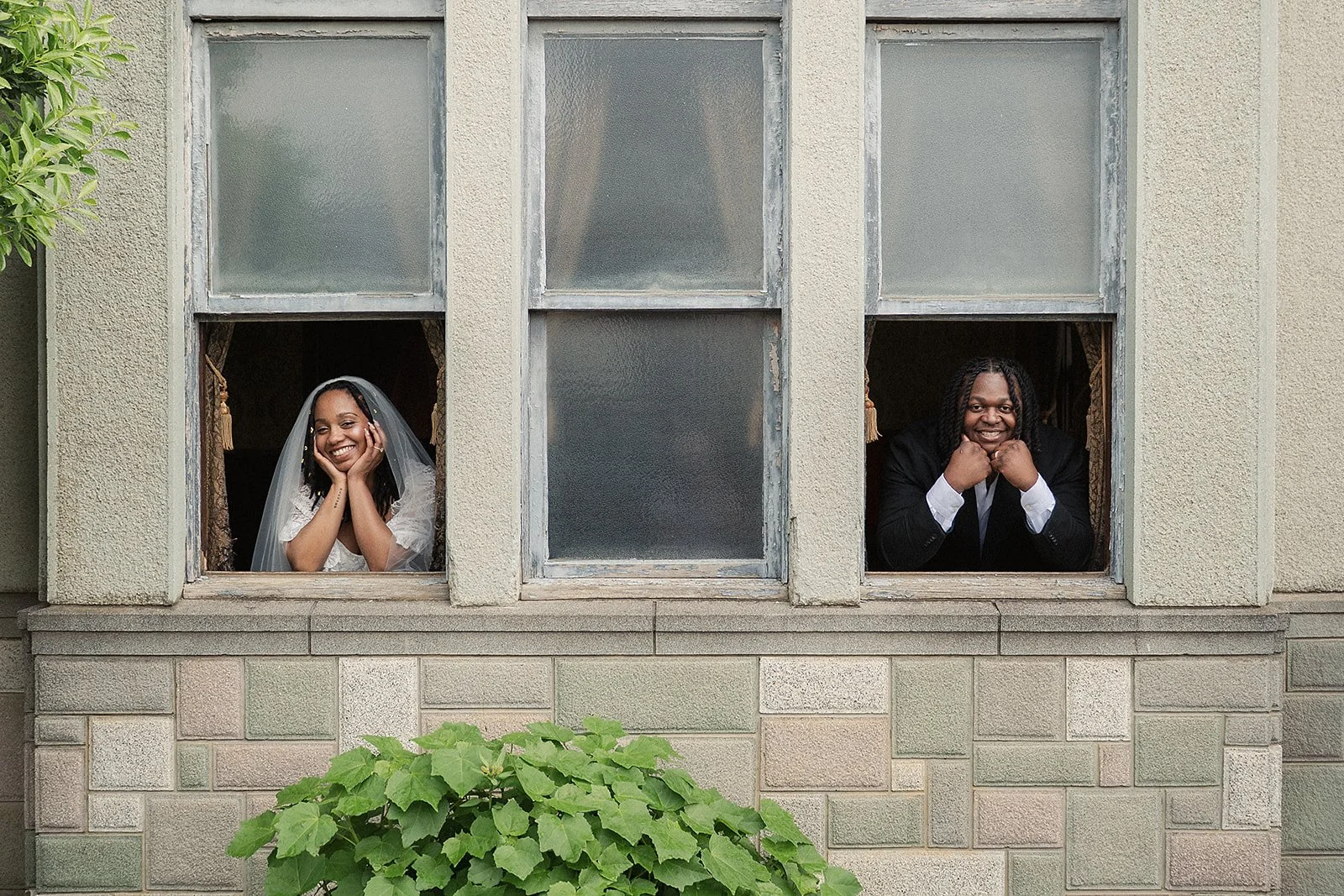 Wedding couple smiling from separate windows at a private Tokyo elopement venue after their ceremony