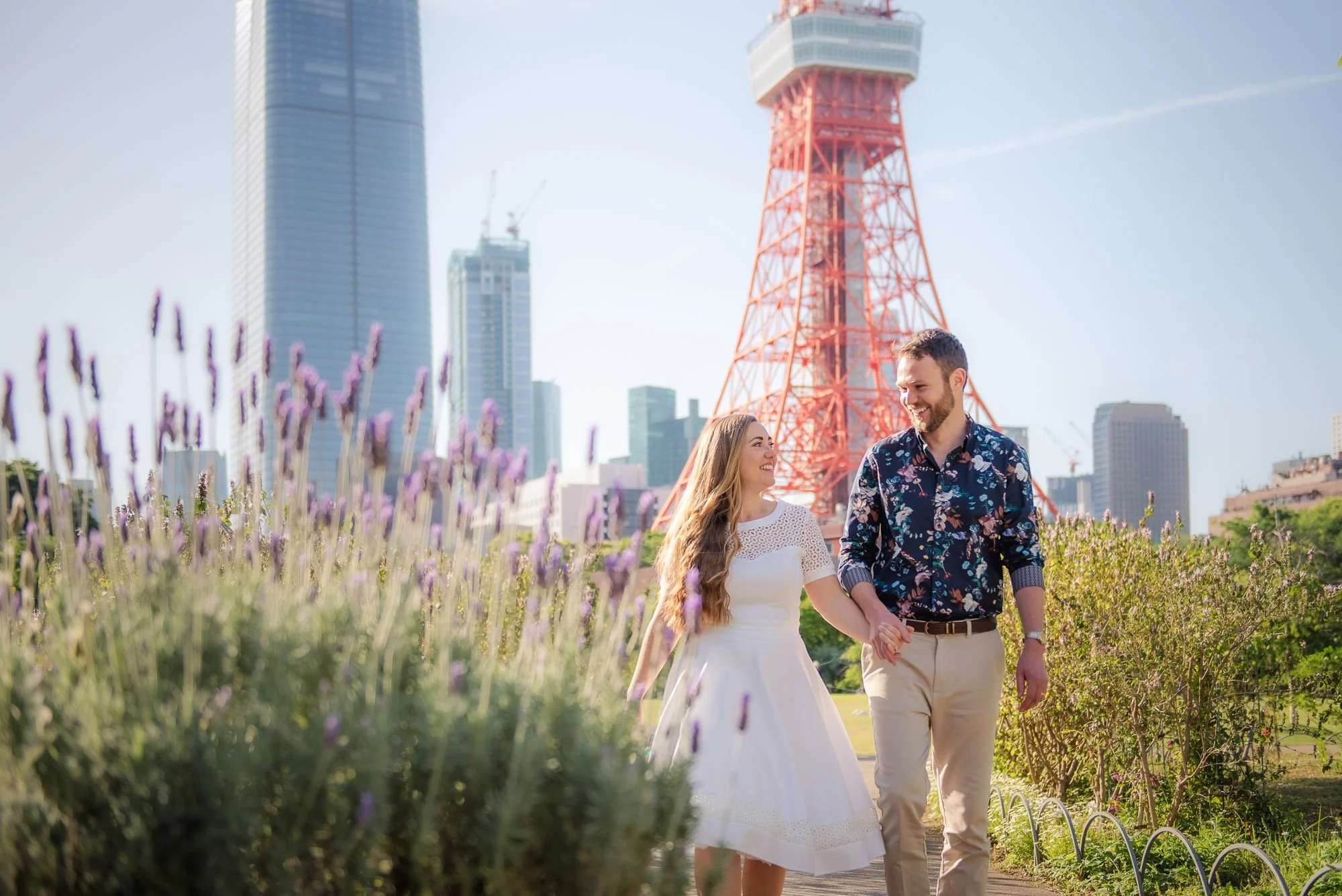 Couple photoshoot in Tokyo with Tokyo Tower and spring flowers, smiling and walking together