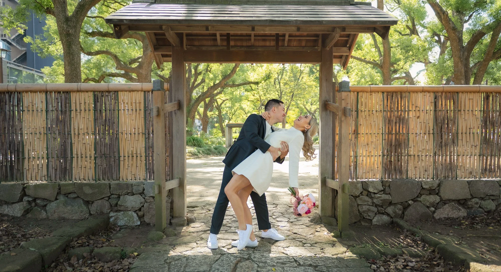 Young couple laughing and hugging in a Tokyo garden.