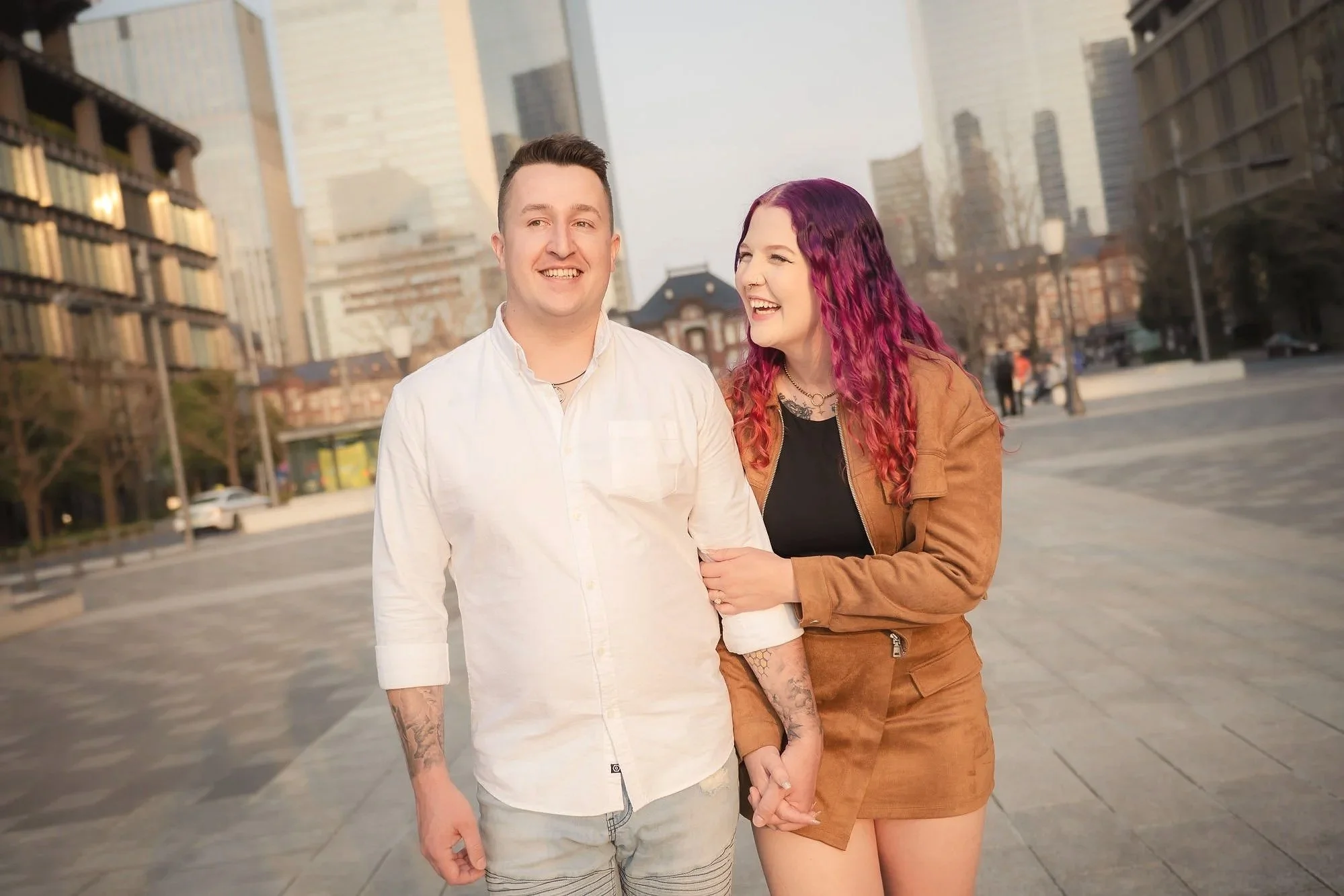 A young couple laughing and walking in Tokyo.