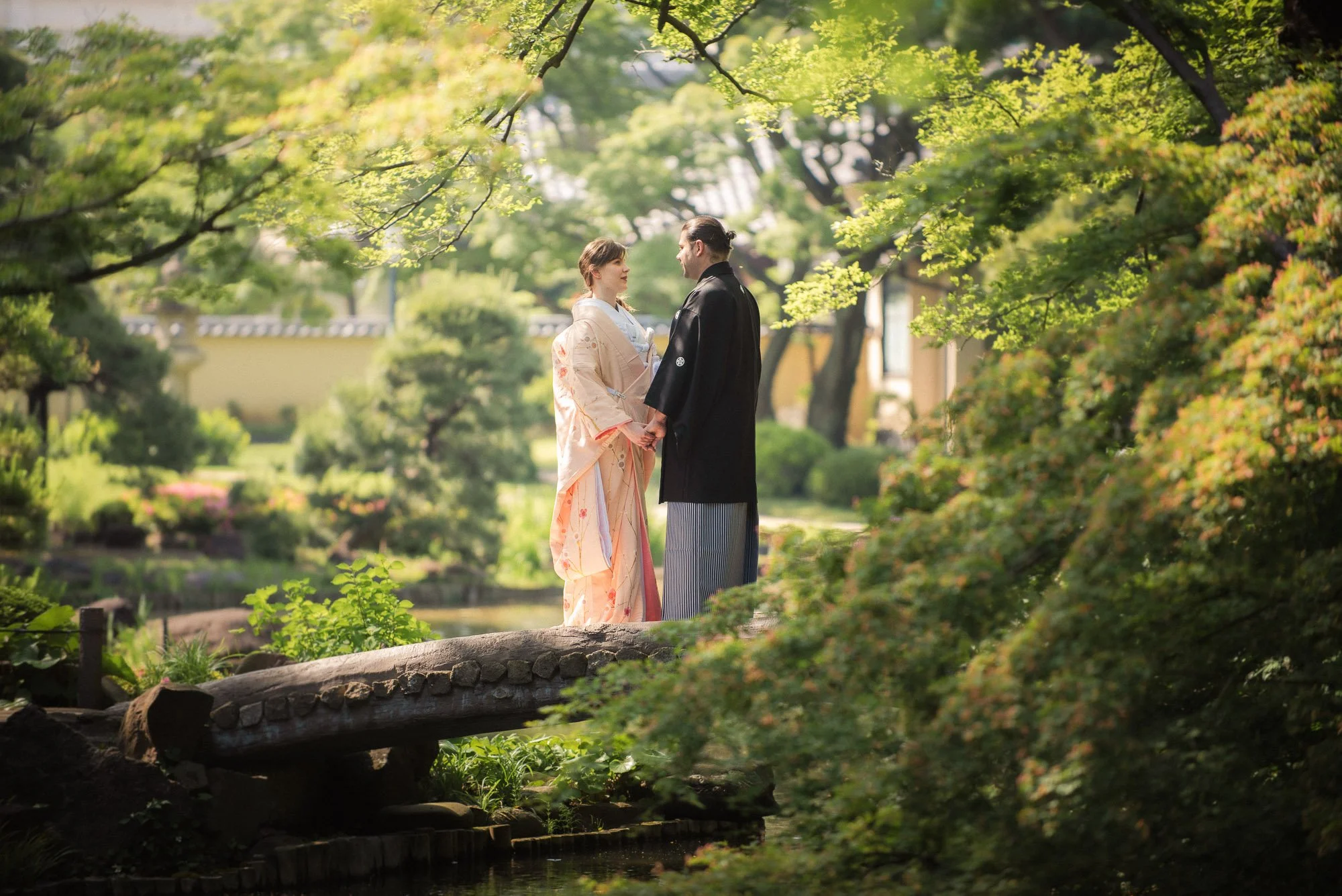Young just-married couple wearing kimonos enjoy a Japanese garden.
