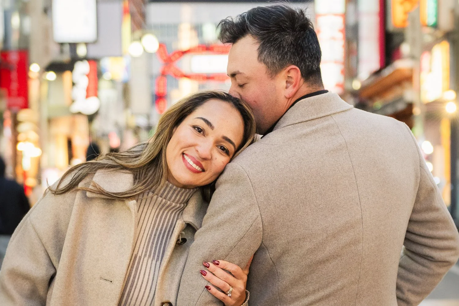 Happy couple embrace in a neon lit street of Tokyo