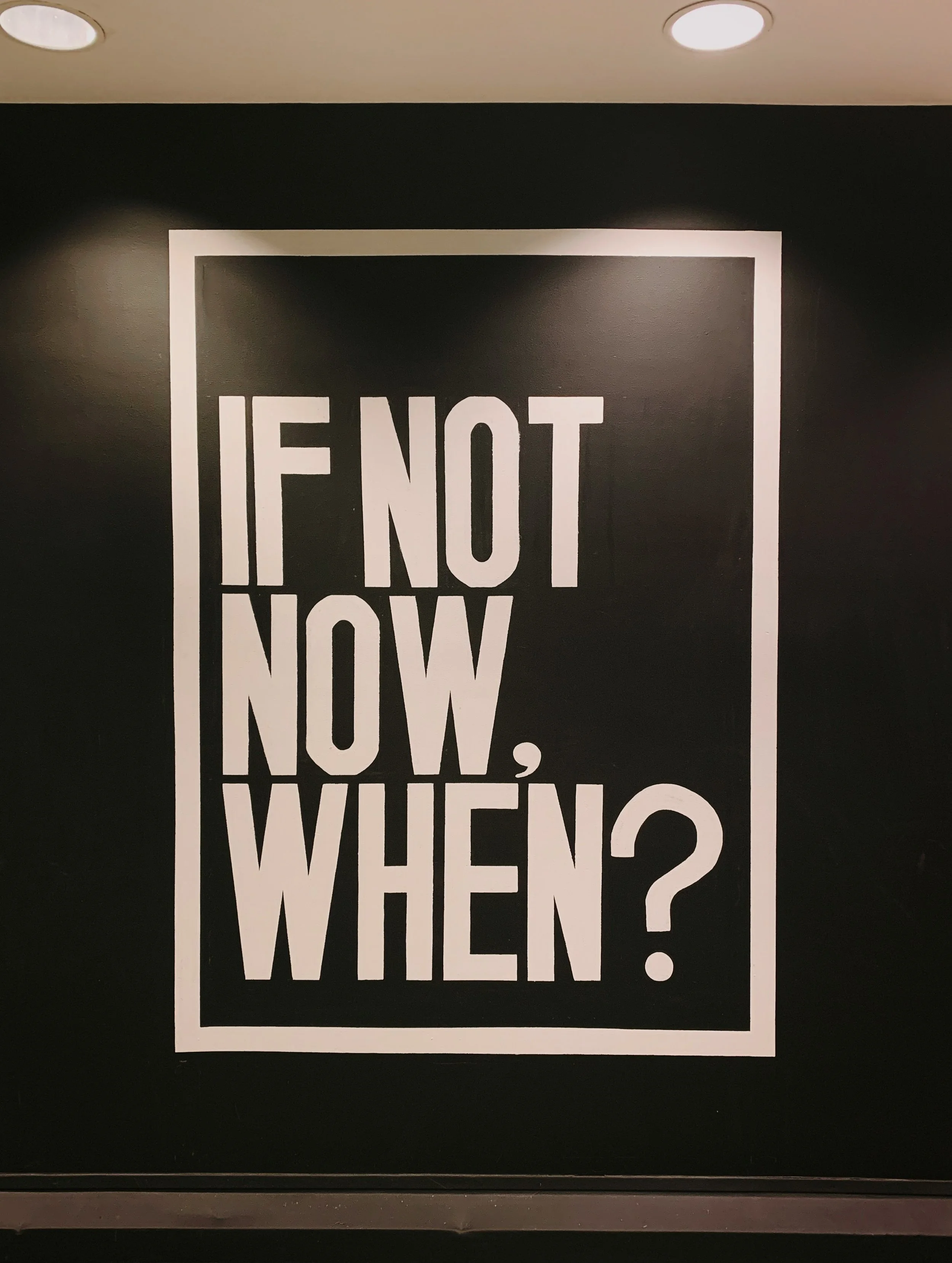 Une affiche avec le texte 'If not now, when?' en lettres blanches sur fond noir.