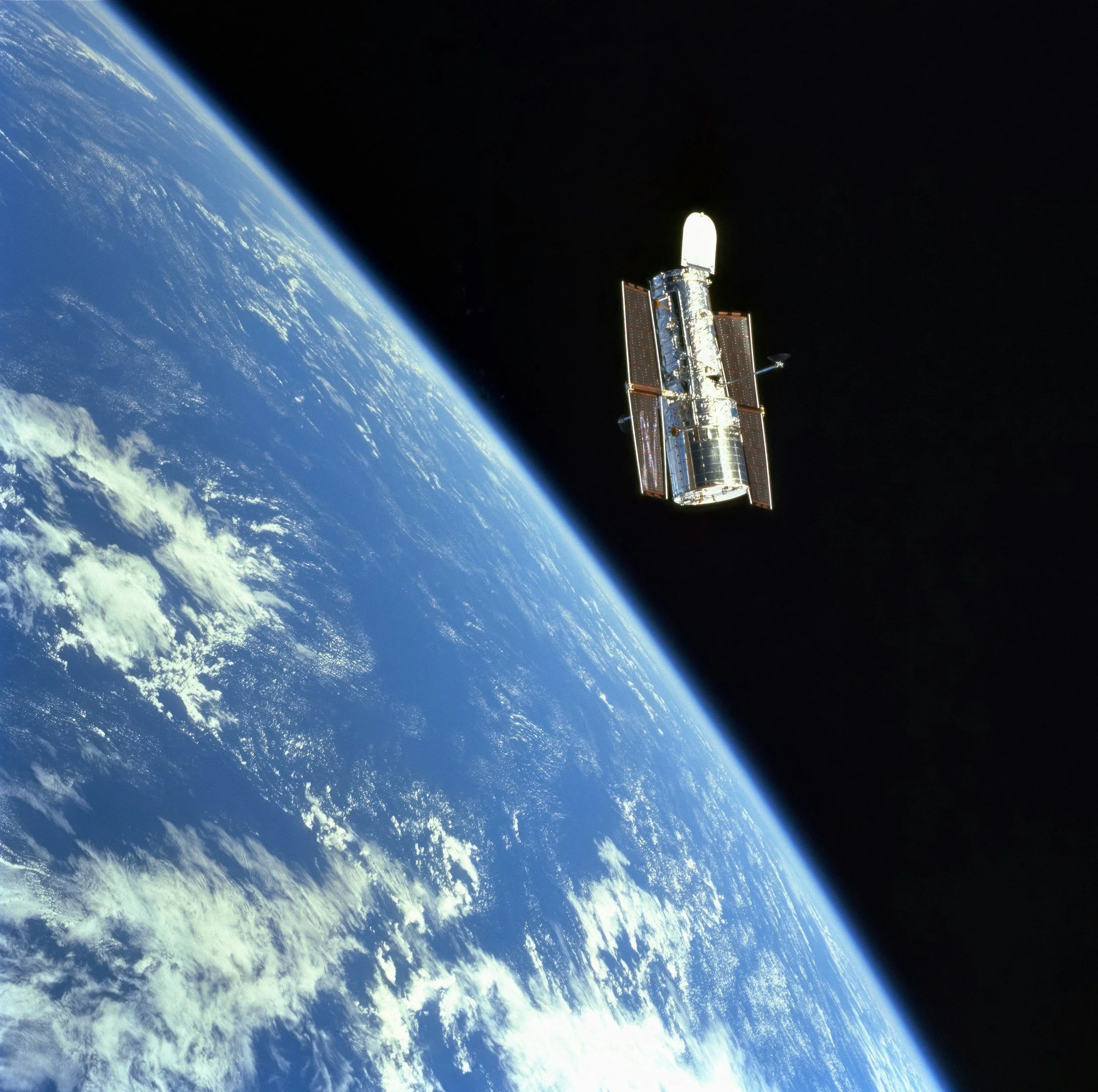 A satellite orbiting Earth in space with the planet's blue surface and cloud cover visible.