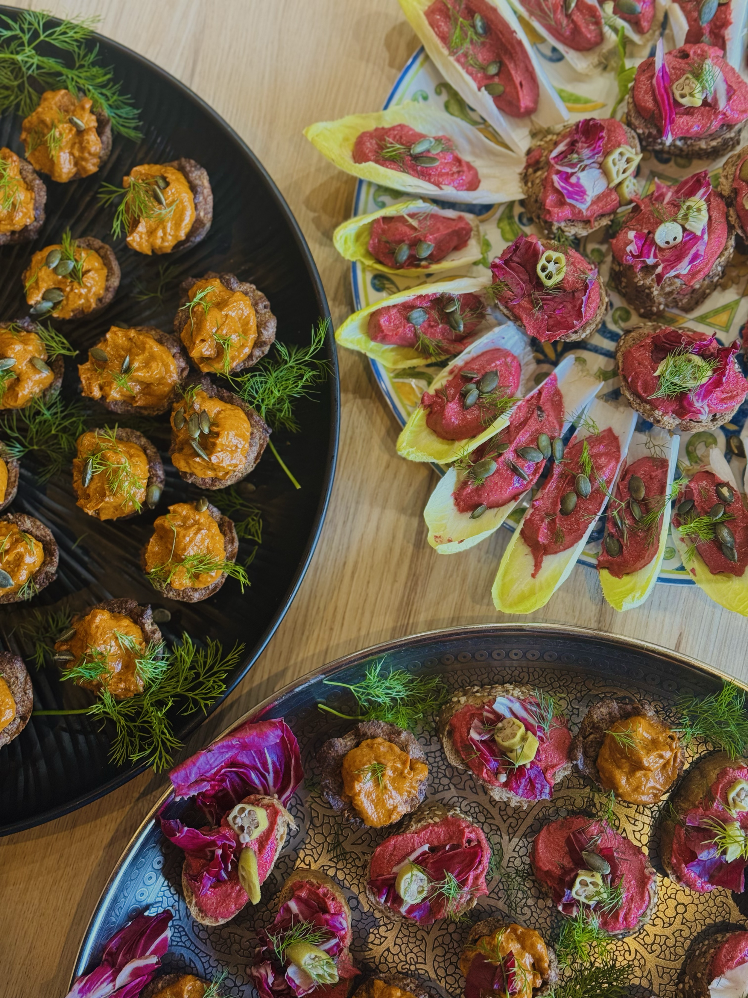 Assorted canapés with various toppings arranged on decorative platters.