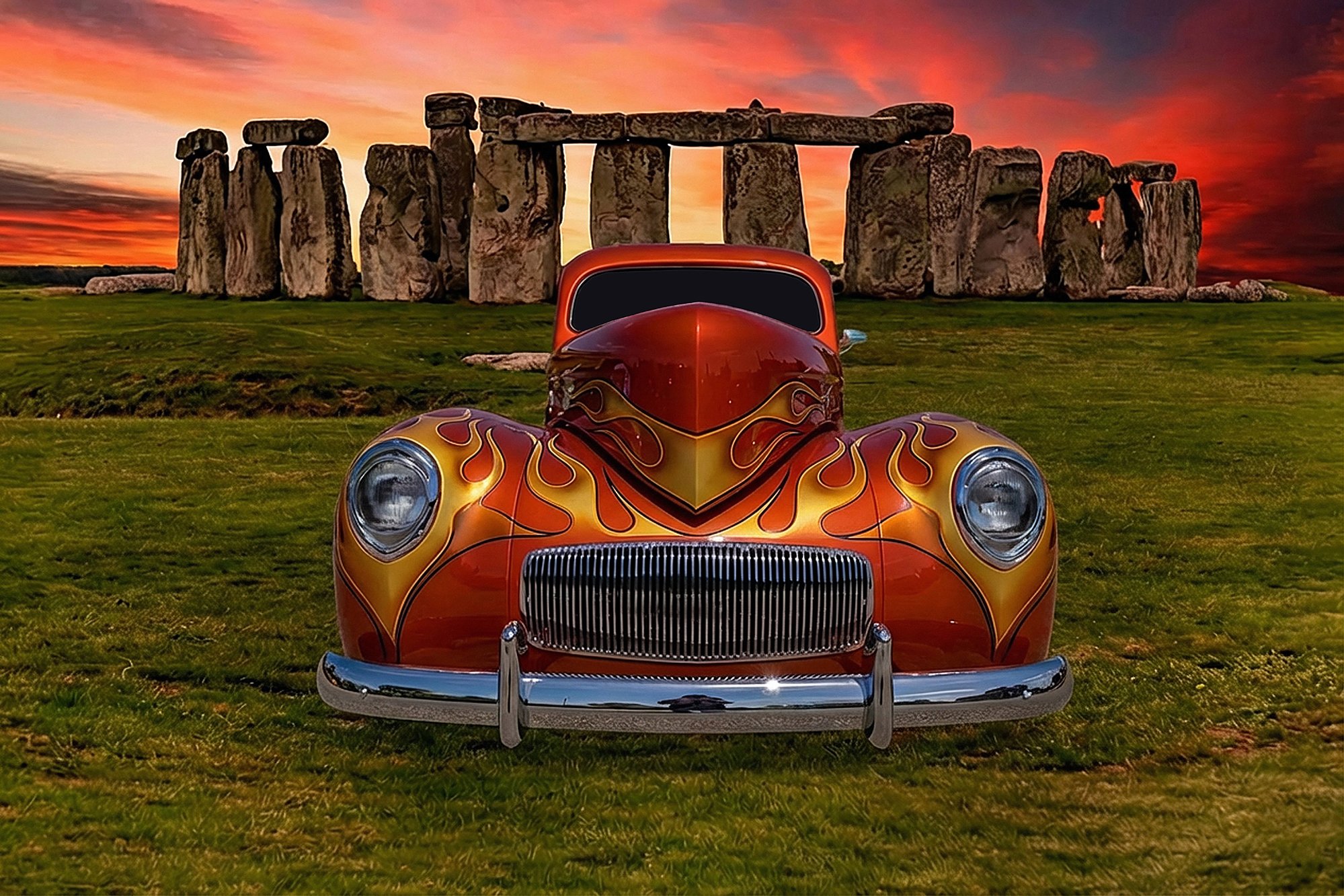 A vintage car with flame decals on its hood and fenders, parked in front of the ancient Stonehenge monument at sunset with a vibrant orange and pink sky.