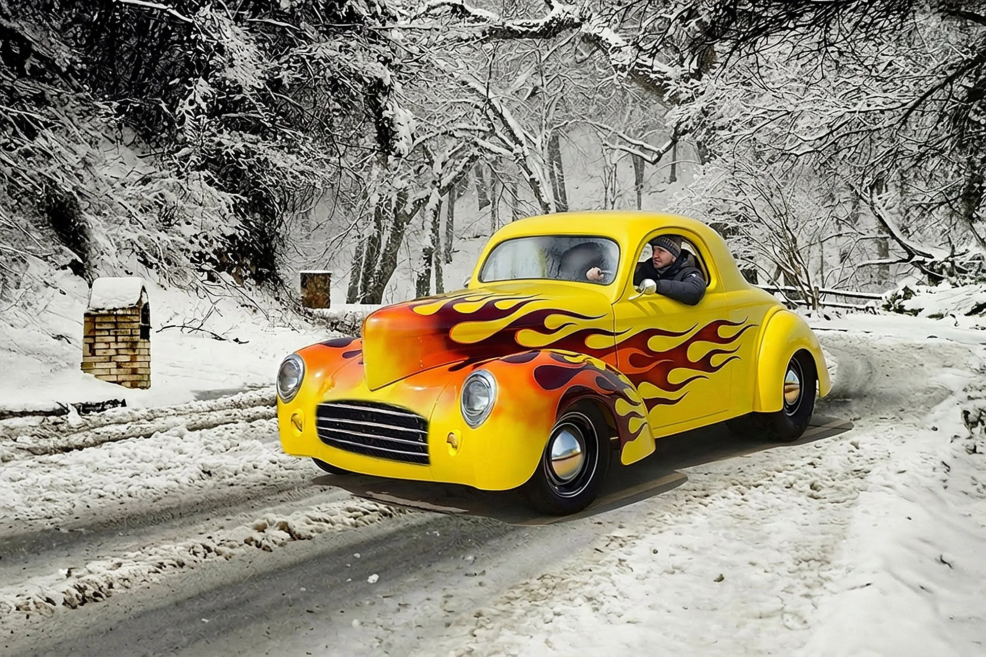 A yellow vintage car with flaming paint design on the front is driving on a snowy road, with snow-covered trees in the background and a person inside wearing winter clothing.