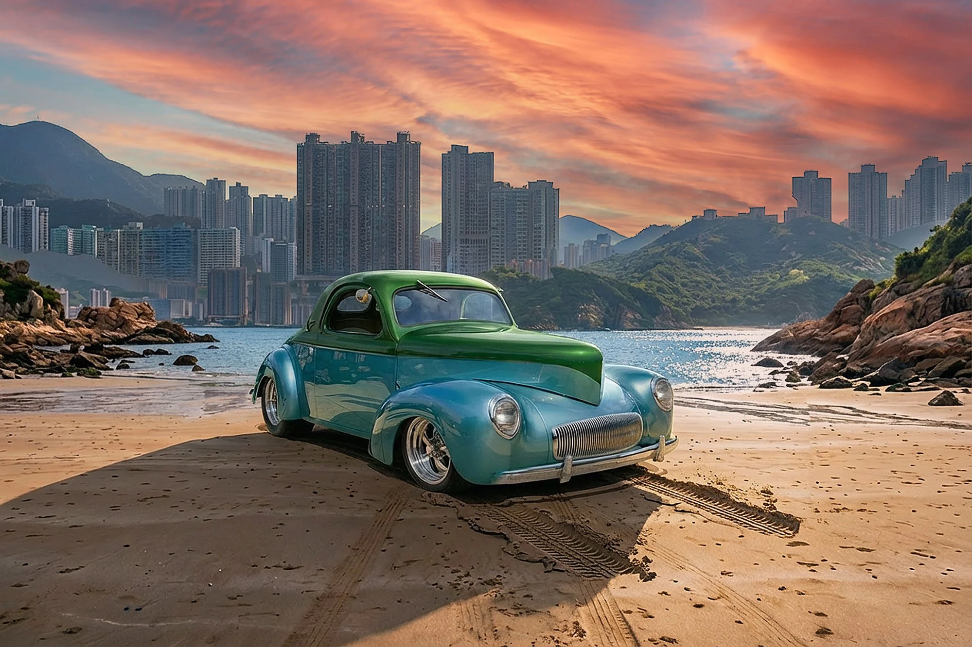 A vintage teal and blue car with rounded design parked on sandy beach, with cityscape and mountains in the background during sunset with colorful sky.