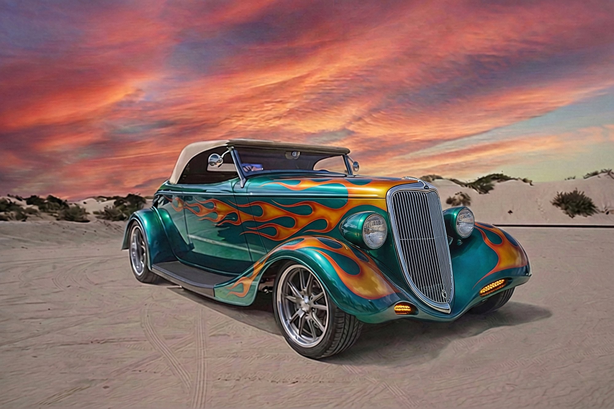 A vintage car with a vibrant teal paint job and flame decals parked on sandy terrain during sunset, with colorful clouds in the sky.