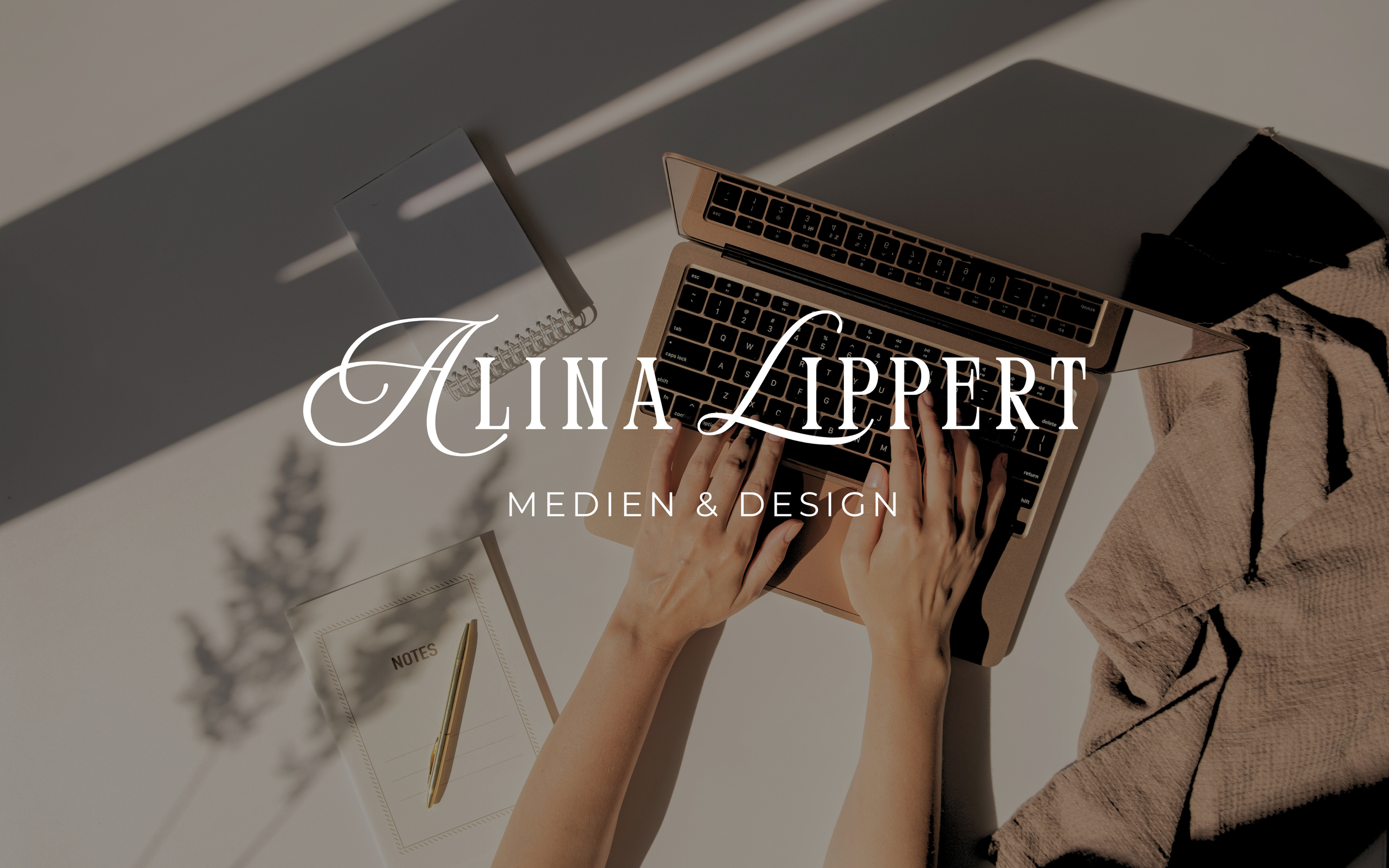 Hände tippen an einem Laptop. Auf dem Tisch befinden sich ein Notizbuch, eine Notiz und ein Stift. Das Licht fällt durch Fenster und wirft Schatten.