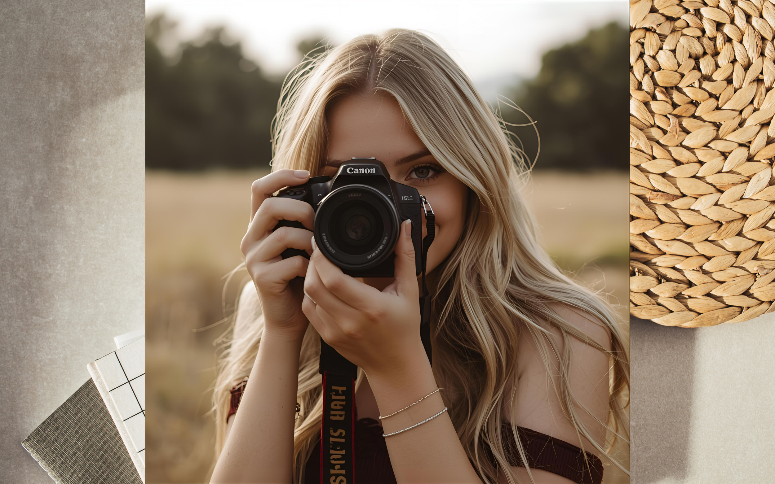 Junge Frau fotografiert mit Spiegelreflexkamera im Freien, rings um sie befindet sich ein Papierblock, ein Teppich und ein Deckel