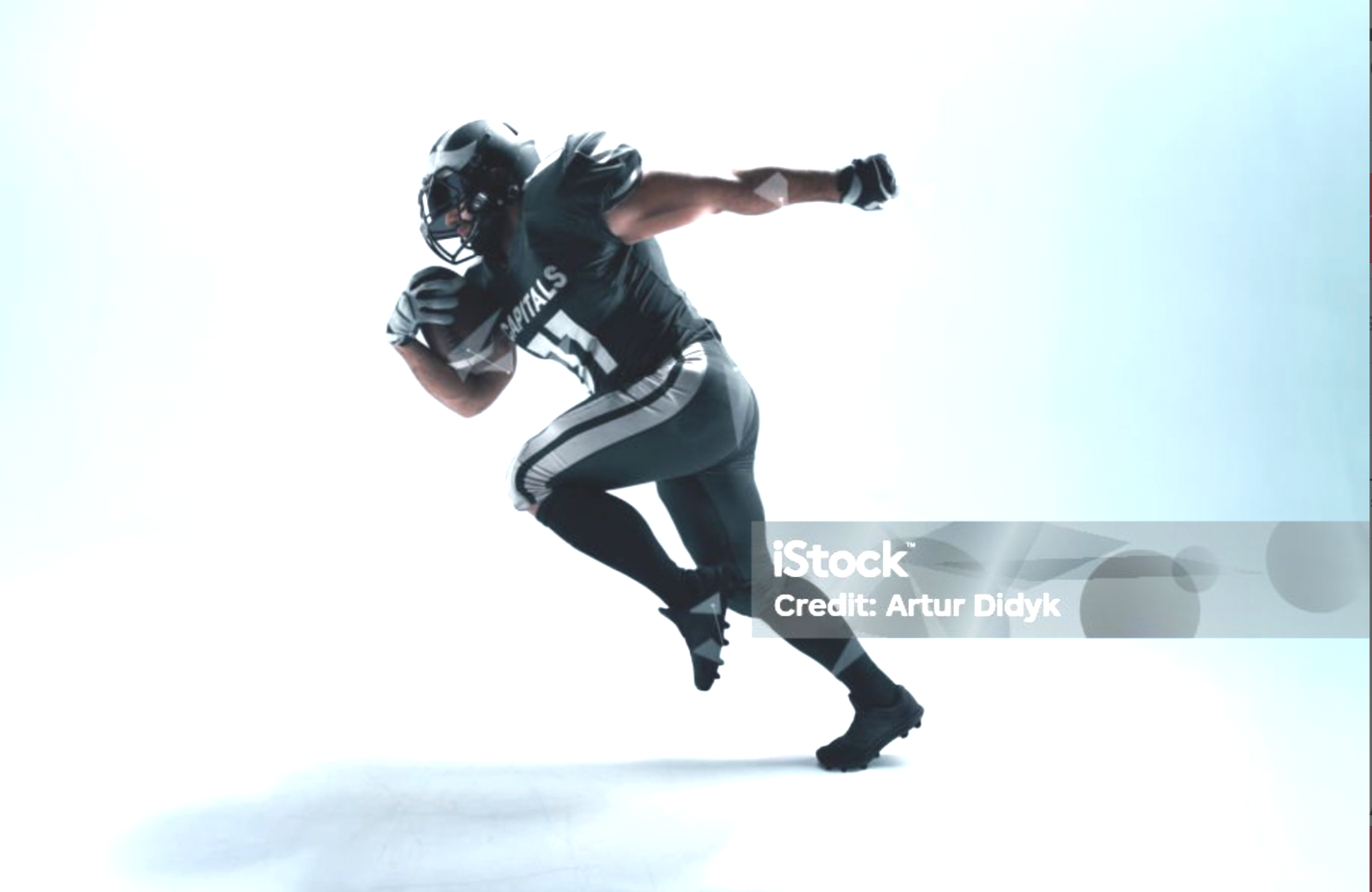 American football player in black and white uniform with number 51, running forward with a helmet and gloves.